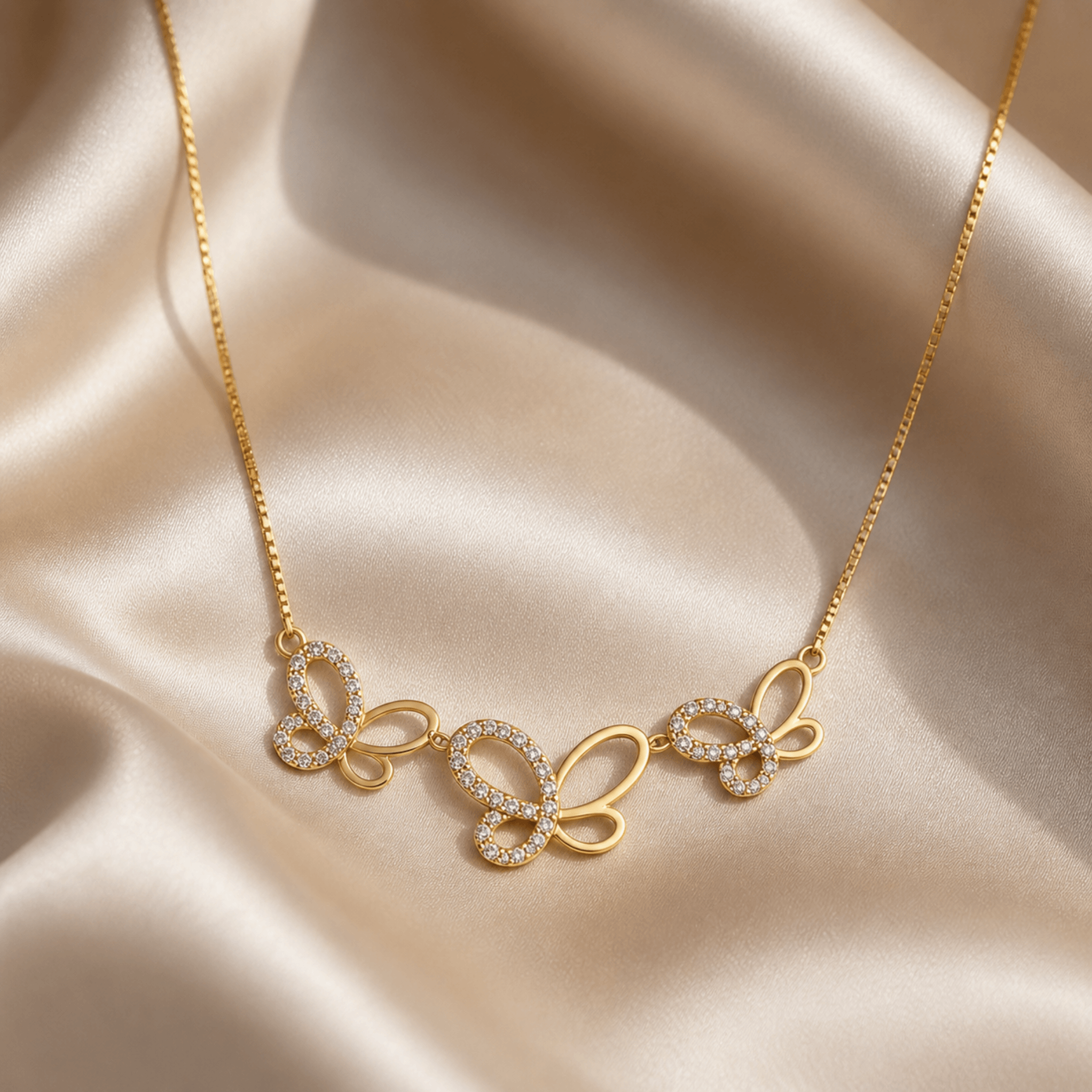 Butterfly Jewelry Set featuring a delicate gold-plated necklace with sparkling butterfly designs on a satin background.